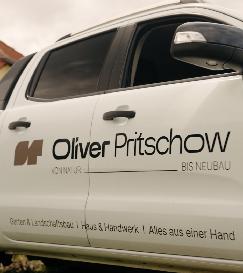 Weiße Fahrzeugtür mit Beschriftung Oliver Pritschow, Garten & Landschaftsbau, Haus & Handwerk, alles aus einer Hand.